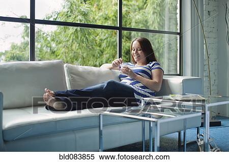 Pregnant Caucasian woman eating on sofa View Large Photo Image Stock Photography - Pregnant Caucasian woman eating on sofa. Fotosearch