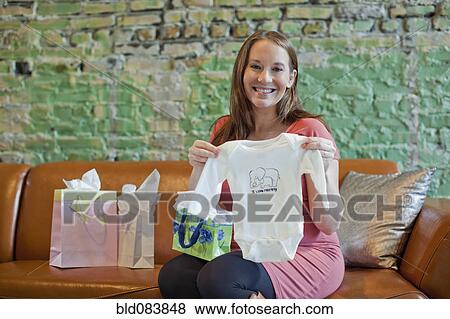 Pregnant Caucasian woman opening baby shower gifts View Large Photo Image Stock Photo - Pregnant Caucasian woman opening baby shower gifts. Fotosearch