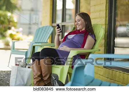 Pregnant Caucasian woman text messaging outdoors View Large Photo Image Stock Photography - Pregnant Caucasian woman text messaging outdoors. Fotosearch