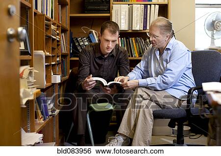 Stock Photograph - Teacher talking with student about book. Fotosearch