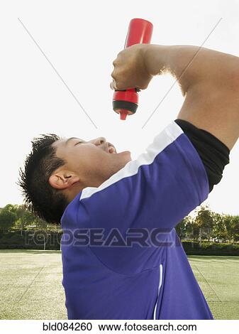 Asian soccer player drinking water on soccer field View Large Photo Image Stock Image - Asian soccer player drinking water on soccer field. Fotosearch