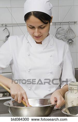 Baker stirring batter in bakery kitchen View Large Photo Image Stock Image - Baker stirring batter in bakery kitchen. Fotosearch