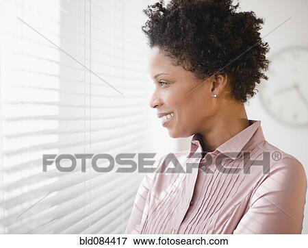 Black businesswoman looking out window View Large Photo Image Stock Photo - Black businesswoman looking out window. Fotosearch