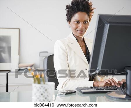 Black businesswoman typing on computer at desk View Large Photo Image Stock Image - Black businesswoman typing on computer at desk. Fotosearch