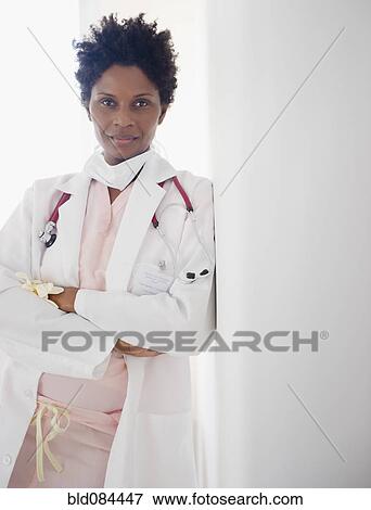 Stock Photo - Black doctor leaning against wall. Fotosearch