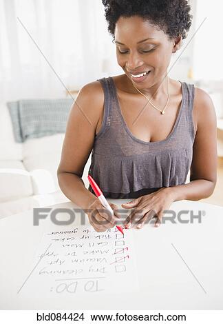 Black woman checking off to do list View Large Photo Image Picture - Black woman checking off to do list. Fotosearch