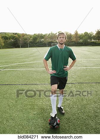 Caucasian soccer player standing on soccer field with ball View Large Photo Image Stock Image - Caucasian soccer player standing on soccer field with ball. Fotosearch