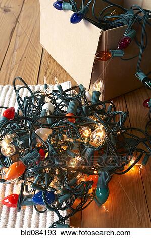 Stock Image - Glowing Christmas lights tangled on floor. Fotosearch