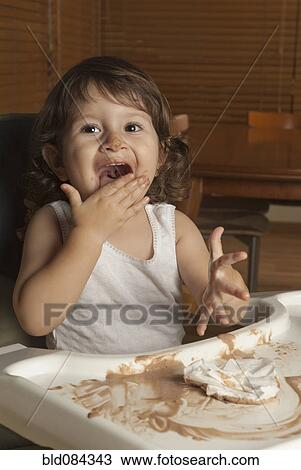 Hispanic baby in high chair licking hand View Large Photo Image Stock Image - Hispanic baby in high chair licking hand. Fotosearch
