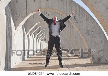 Picture - Hispanic businessman jumping in mid-air. Fotosearch