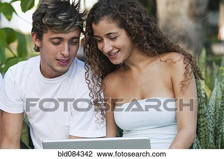 Stock Image - Hispanic couple using laptop together. Fotosearch
