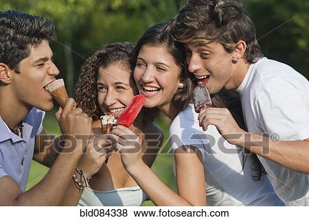 Stock Photo - Hispanic friends eating ice cream together. Fotosearch