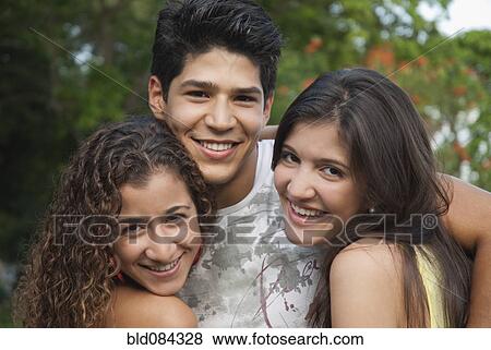 Stock Photo - Hispanic friends hugging. Fotosearch