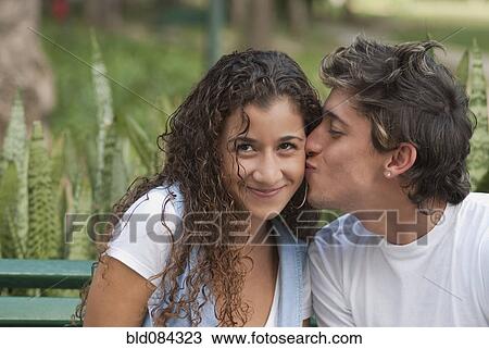 Stock Image - Hispanic man kissing girlfriend. Fotosearch