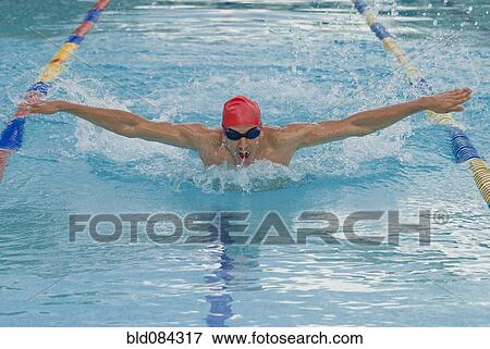Stock Photo - Hispanic man swimming in swimming pool. Fotosearch