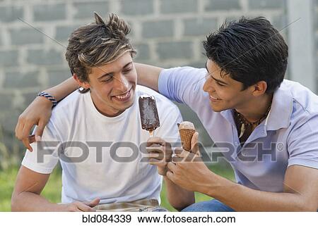 Hispanic men eating ice cream together View Large Photo Image Stock Photo - Hispanic men eating ice cream together. Fotosearch