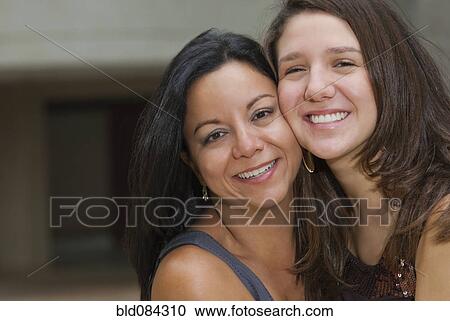 Stock Image - Hispanic mother and daughter hugging. Fotosearch