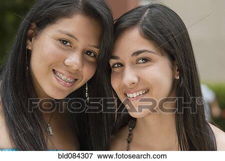 Stock Photo - Hispanic sisters smiling. Fotosearch