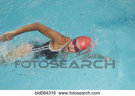 Stock Photograph - Hispanic woman swimming in swimming pool. Fotosearch
