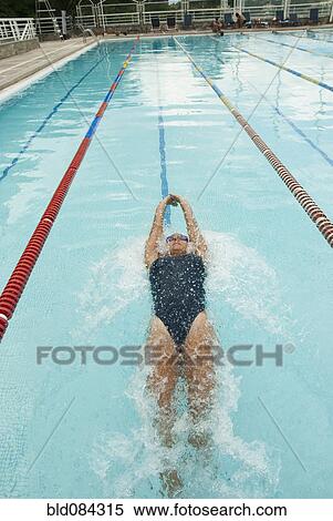 Stock Photography - Hispanic woman swimming in swimming pool. Fotosearch