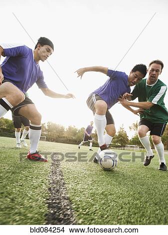 Picture - Men playing soccer on soccer field. Fotosearch