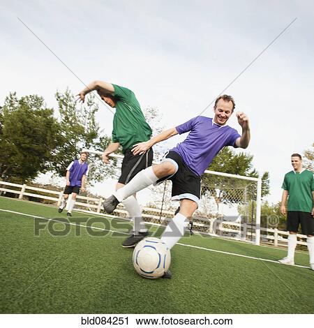 Men playing soccer on soccer field View Large Photo Image Stock Image - Men playing soccer on soccer field. Fotosearch