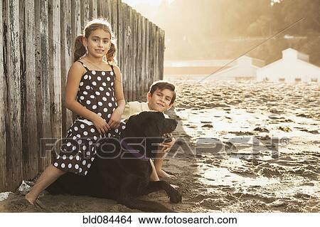Mixed race brother and sister enjoying beach with dog View Large Photo Image Picture - Mixed race brother and sister enjoying beach with dog. Fotosearch