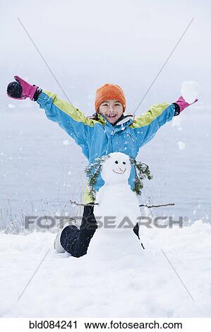 Mixed race girl building snowman View Large Photo Image Stock Image - Mixed race girl building snowman. Fotosearch