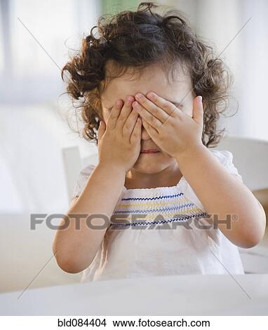 Picture - Mixed race girl covering her eyes. Fotosearch