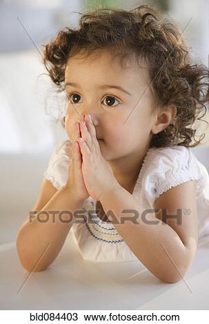 Stock Image - Mixed race girl praying. Fotosearch