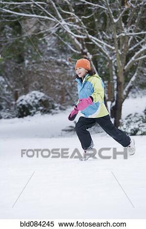 Stock Photography - Mixed race girl running in snow. Fotosearch