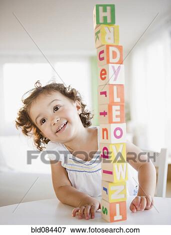 Stock Photo - Mixed race girl stacking blocks. Fotosearch