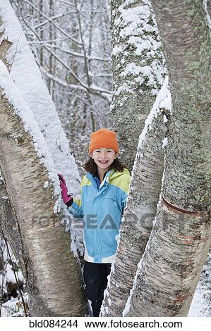 Mixed race girl standing on snowy tree View Large Photo Image Picture - Mixed race girl standing on snowy tree. Fotosearch