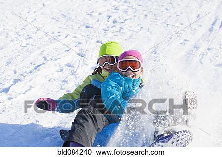 Mixed race girls sledding in snow View Large Photo Image Stock Image - Mixed race girls sledding in snow. Fotosearch