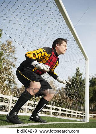 Stock Photo - Mixed race goalkeeper protecting goal. Fotosearch