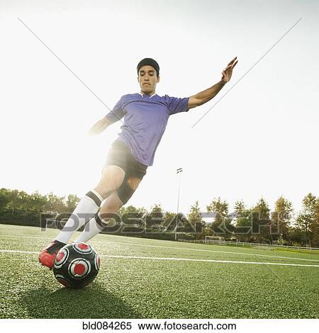 Mixed race soccer player kicking soccer ball View Large Photo Image Stock Photography - Mixed race soccer player kicking soccer ball. Fotosearch