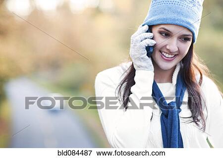 Mixed race woman in cap talking on cell phone View Large Photo Image Stock Photo - Mixed race woman in cap talking on cell phone. Fotosearch