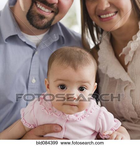 Mother and father holding baby daughter View Large Photo Image Stock Photo - Mother and father holding baby daughter. Fotosearch