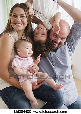 Stock Image - Mother and father playing with daughters. Fotosearch