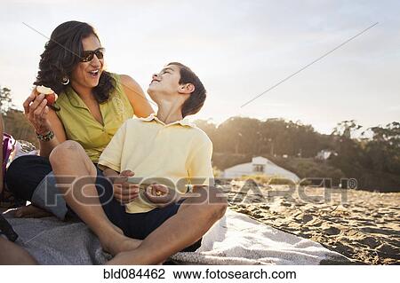 Mother and son enjoying picnic on beach View Large Photo Image Stock Image - Mother and son enjoying picnic on beach. Fotosearch