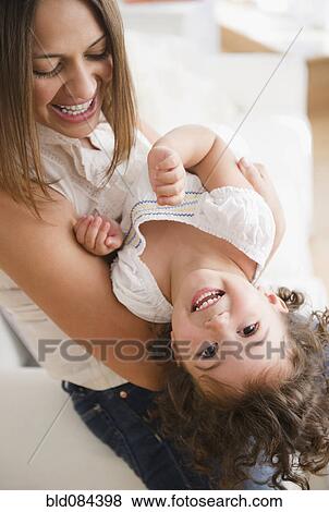 Mother lifting laughing daughter View Large Photo Image Stock Photo - Mother lifting laughing daughter. Fotosearch