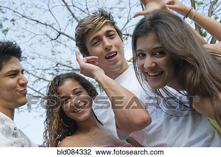 Stock Image - Playful Hispanic friends smiling. Fotosearch