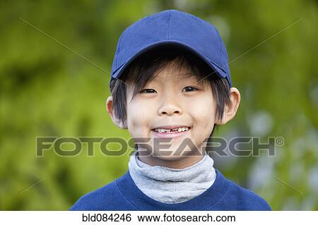 Stock Photograph - Smiling Korean boy in baseball cap. Fotosearch