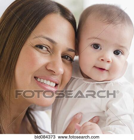 Stock Image - Smiling mother holding baby. Fotosearch
