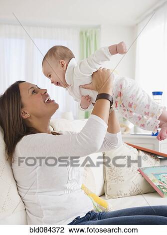 Smiling mother lifting baby View Large Photo Image Stock Image - Smiling mother lifting baby. Fotosearch