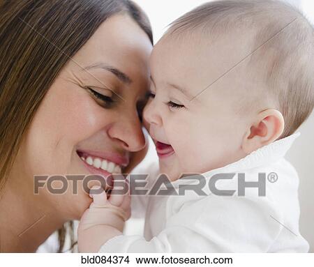 Smiling mother playing with baby View Large Photo Image Picture - Smiling mother playing with baby. Fotosearch
