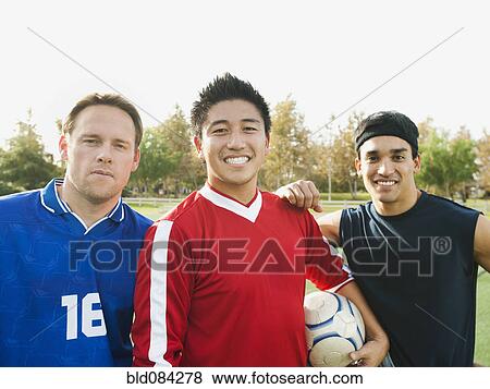 Stock Photo - Smiling soccer players with ball. Fotosearch