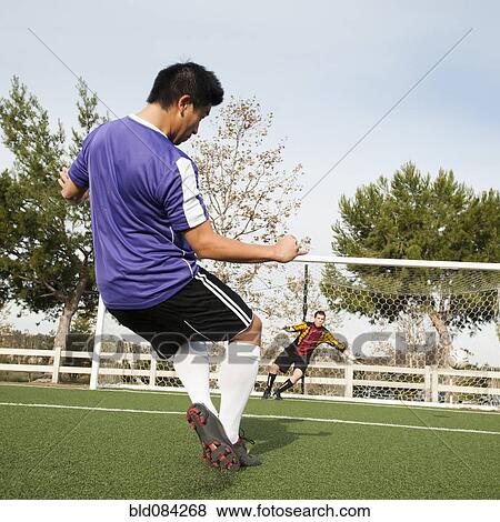Soccer Player Kicking Ball Into Goal On Soccer Field Stock Photo Bld Fotosearch