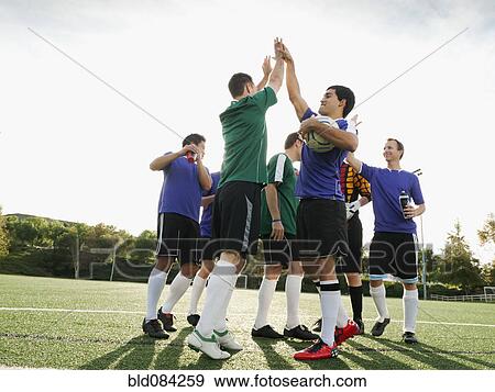 Stock Photo - Soccer players cheering on soccer field. Fotosearch