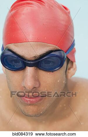 Stock Photo - Wet Hispanic swimmer in goggles and swimming cap. Fotosearch